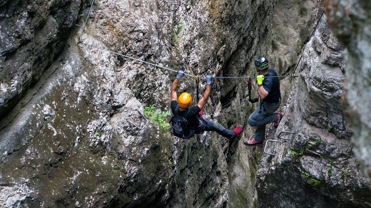 Pratiquant sur une via ferrata offrant une vue spectaculaire sur la vallée du Queyras.