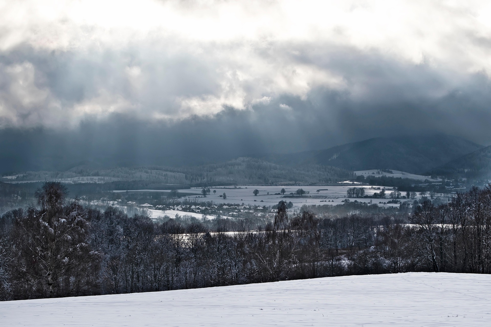 Paysage de vall&eacute;e enneig&eacute;e sous un ciel hivernal en montagne