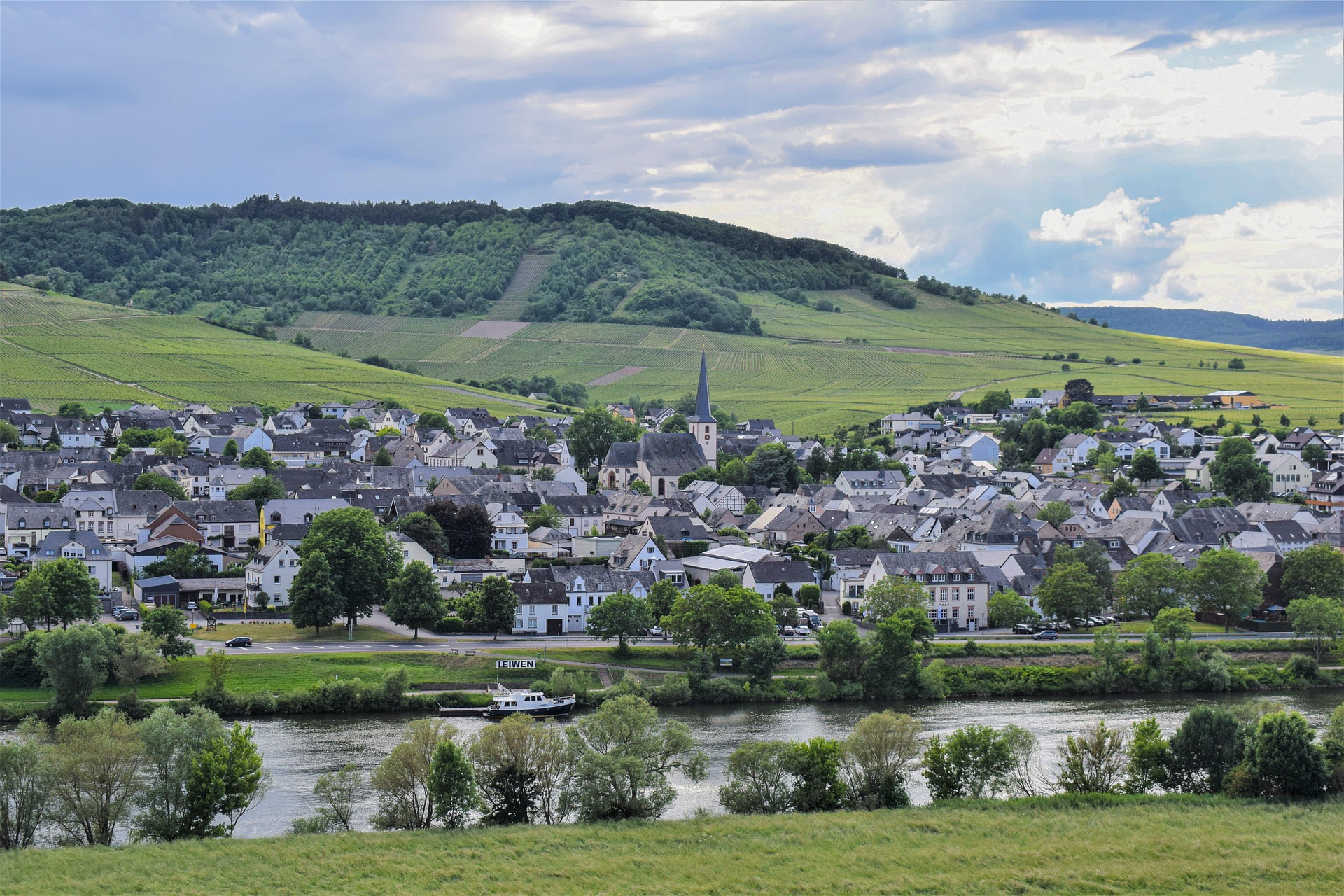 Village typique avec &eacute;glise et rivi&egrave;re en vall&eacute;e montagneuse